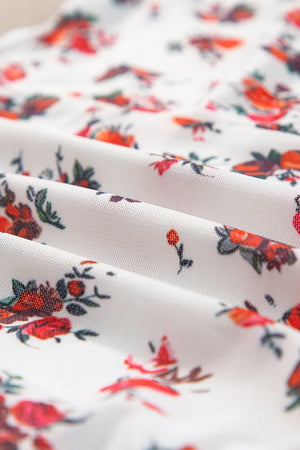Floral frilled trim fabric detail, highlighting vibrant red and orange flower pattern on white background.