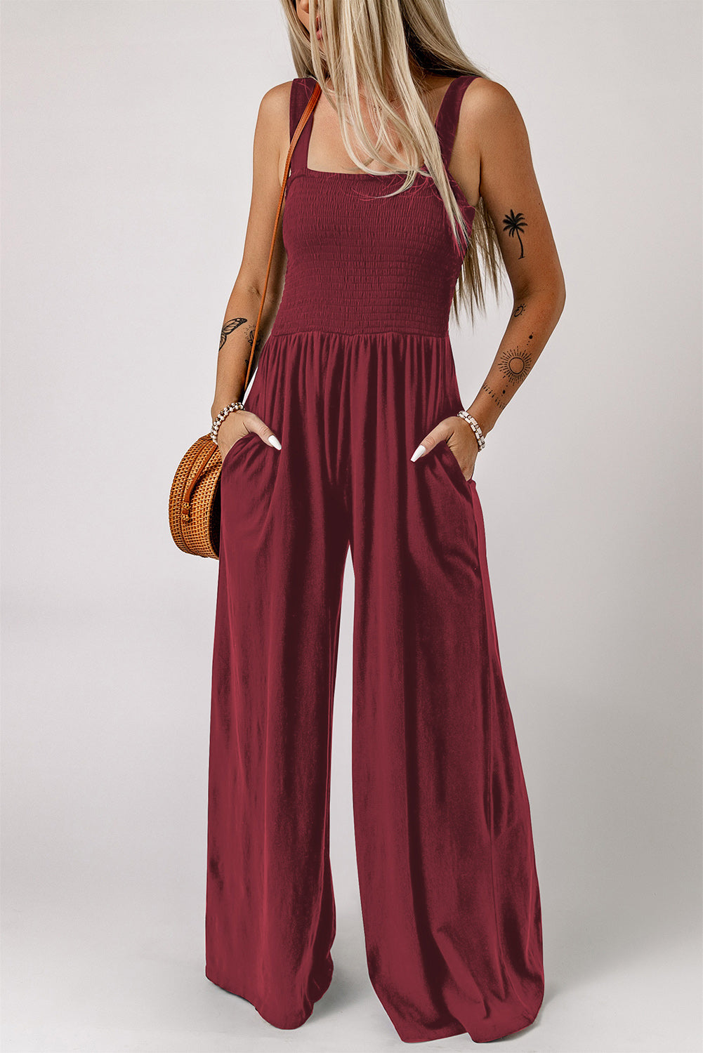 Smocked square neck wide leg jumpsuit with pockets in solid color.