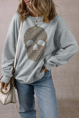 Skull round neck long sleeve sweatshirt with rhinestone design, worn by a person with a casual outfit.