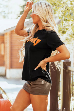 Spooky round neck short sleeve black t-shirt, slightly stretchy, worn by a person outdoors.