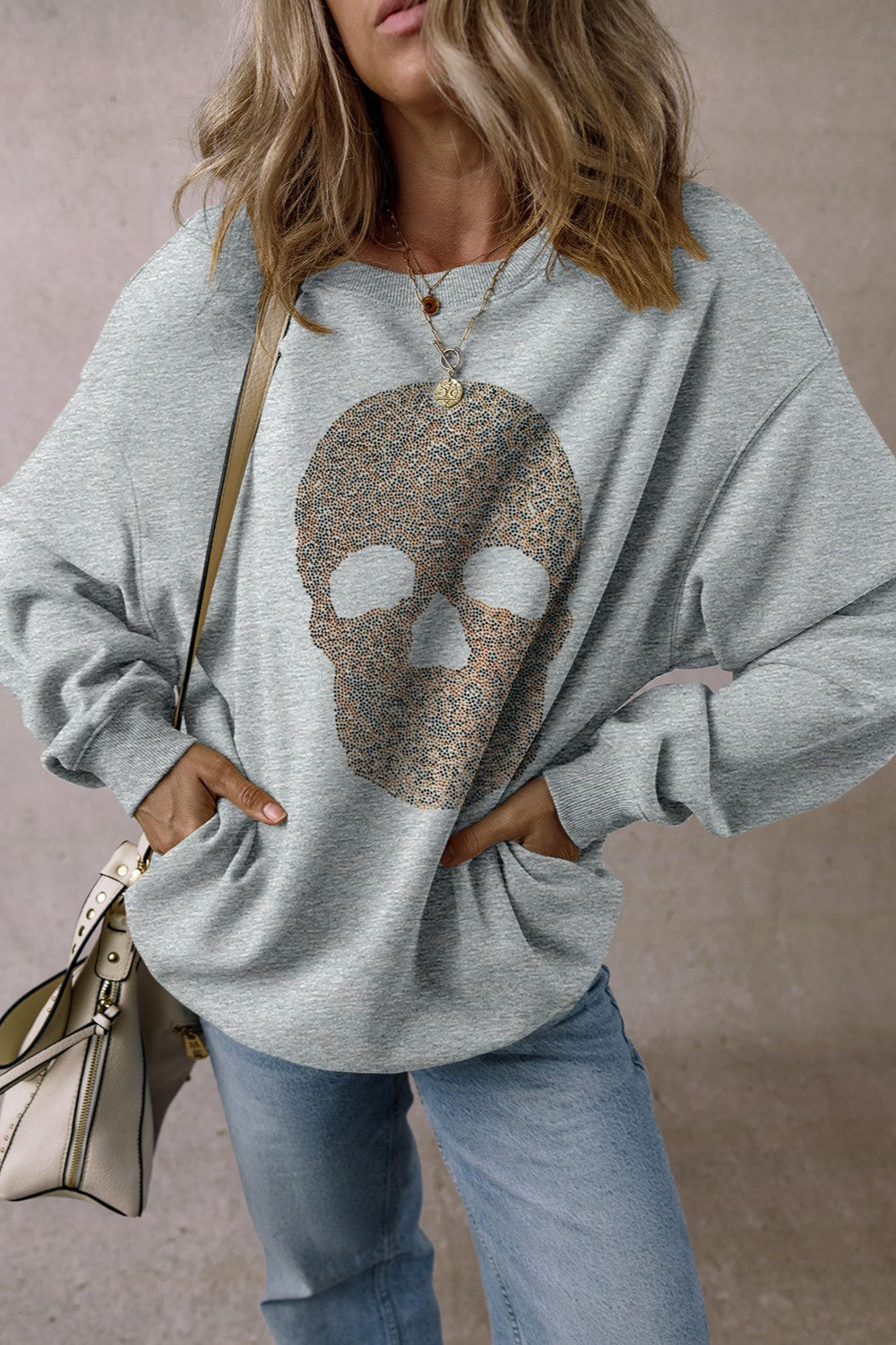 Skull round neck long sleeve sweatshirt with rhinestone embellishment, made of polyester and cotton blend.