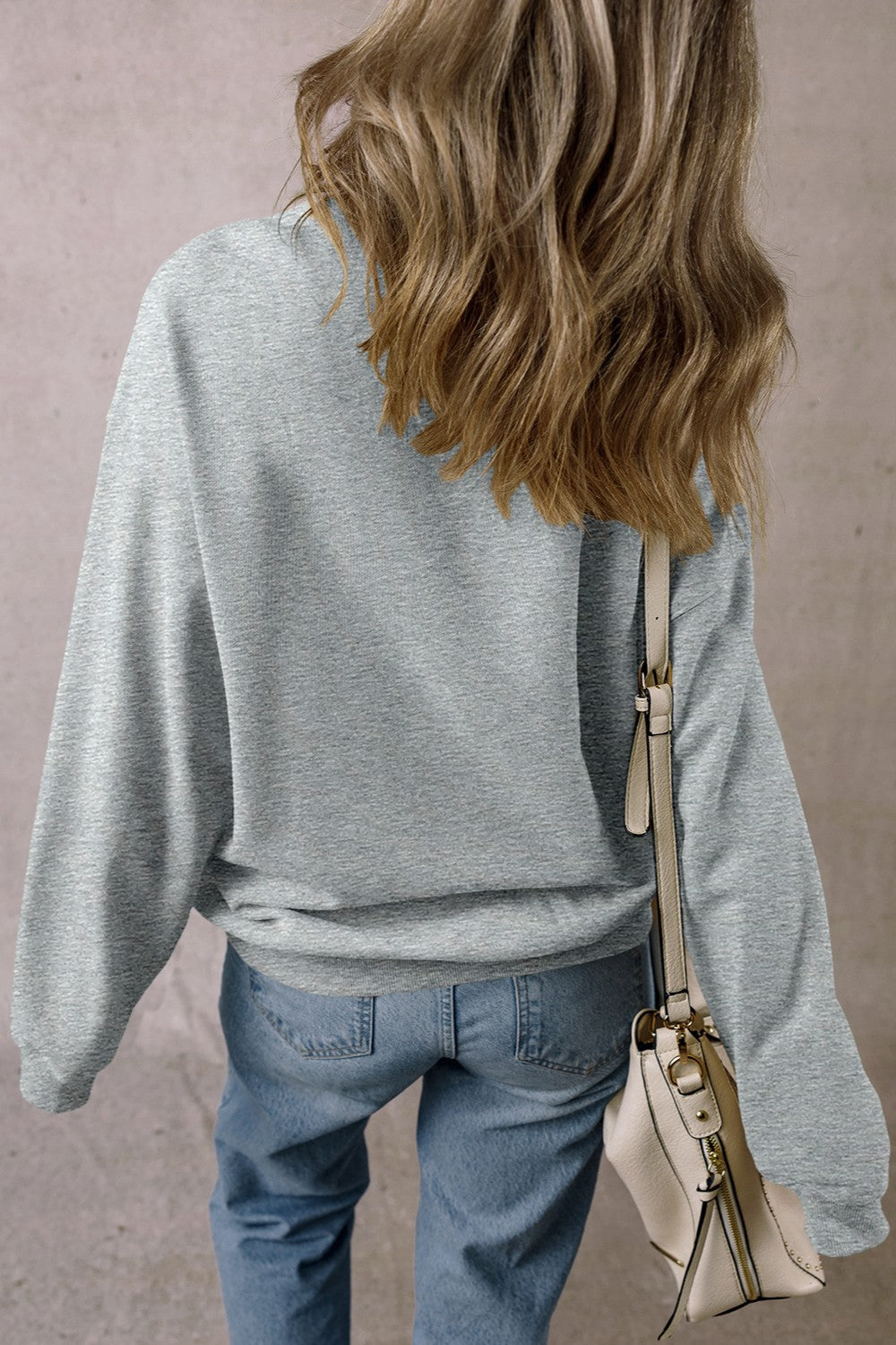 Skull Round Neck Long Sleeve Sweatshirt in gray, featuring rhinestones, worn by a model with a beige bag, polyester and cotton blend.