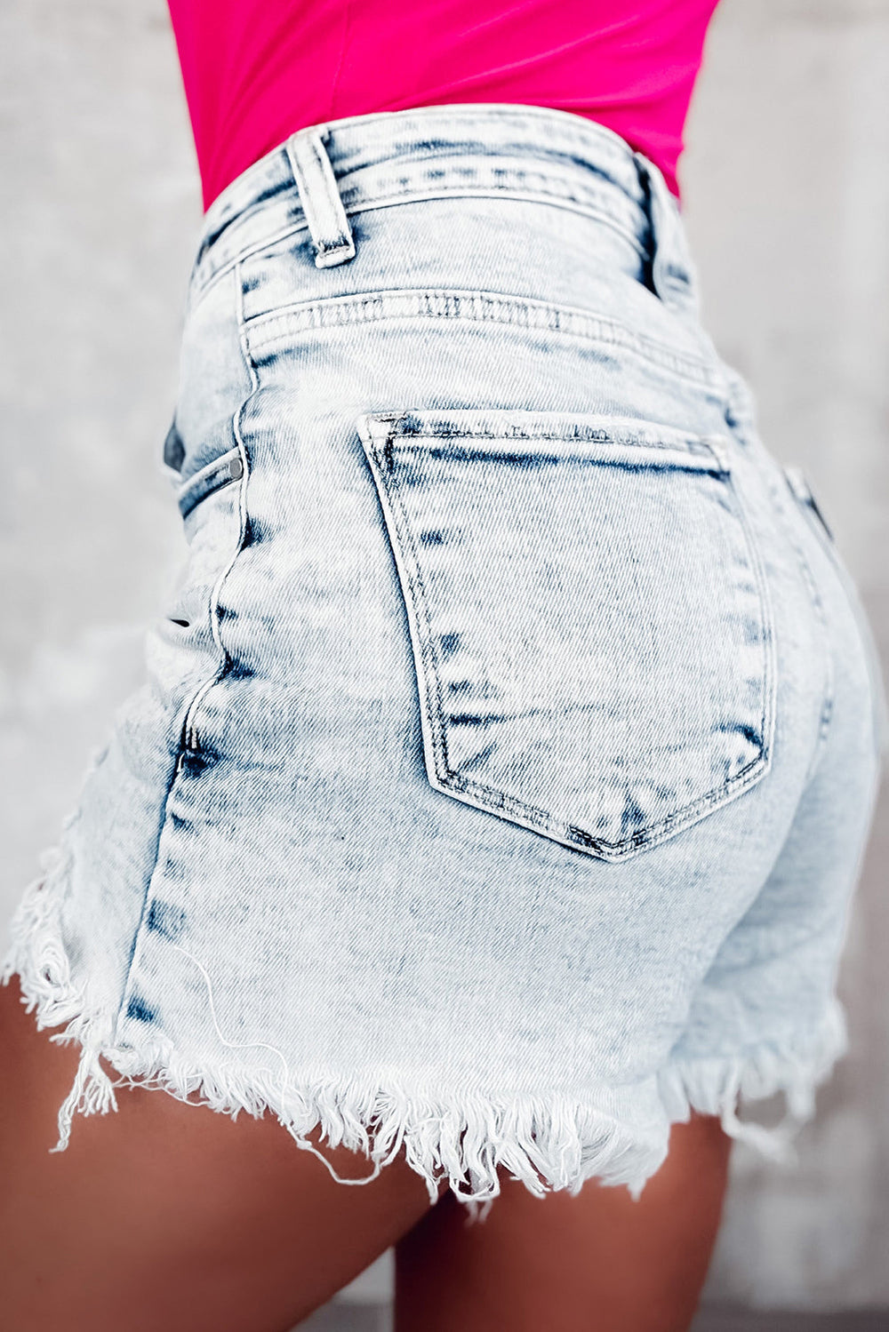 Raw hem buttoned denim shorts with pockets in light wash.