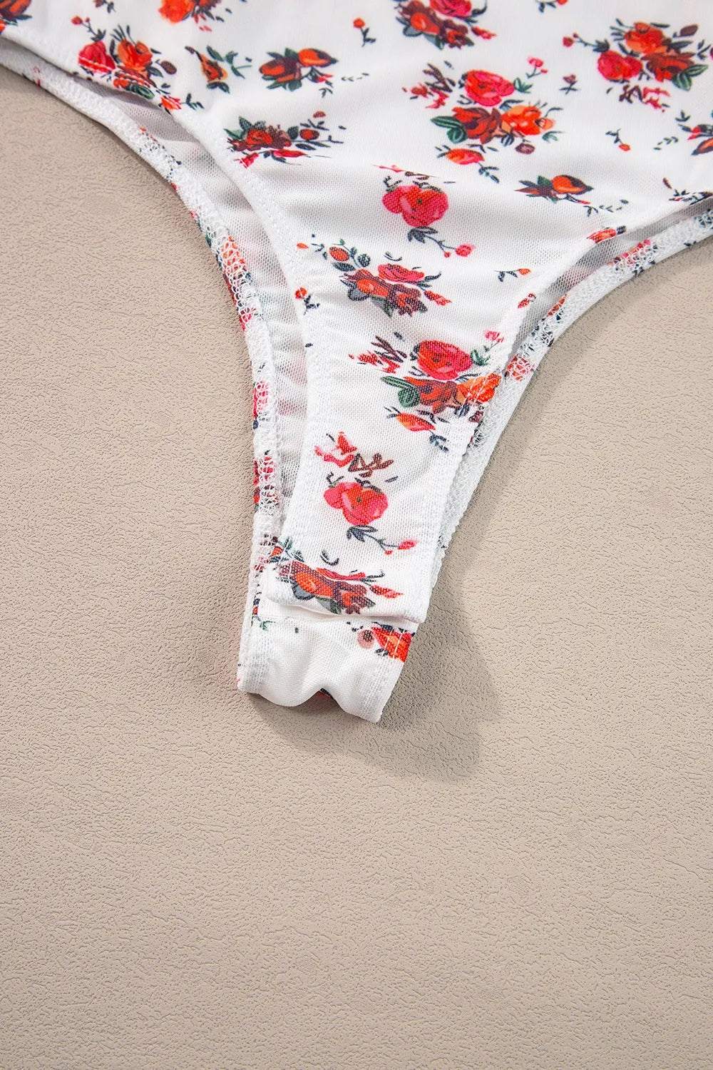 Floral frilled trim spaghetti strap bodysuit with red and orange flowers.