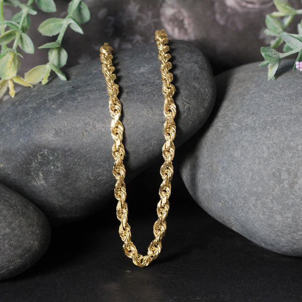 14k yellow gold solid diamond cut rope chain 5mm with lobster clasp displayed on black stones