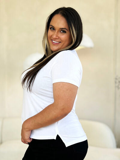 Woman wearing Basic Bae Full Size Round Neck Short Sleeve T-Shirt in white with side slit detail.