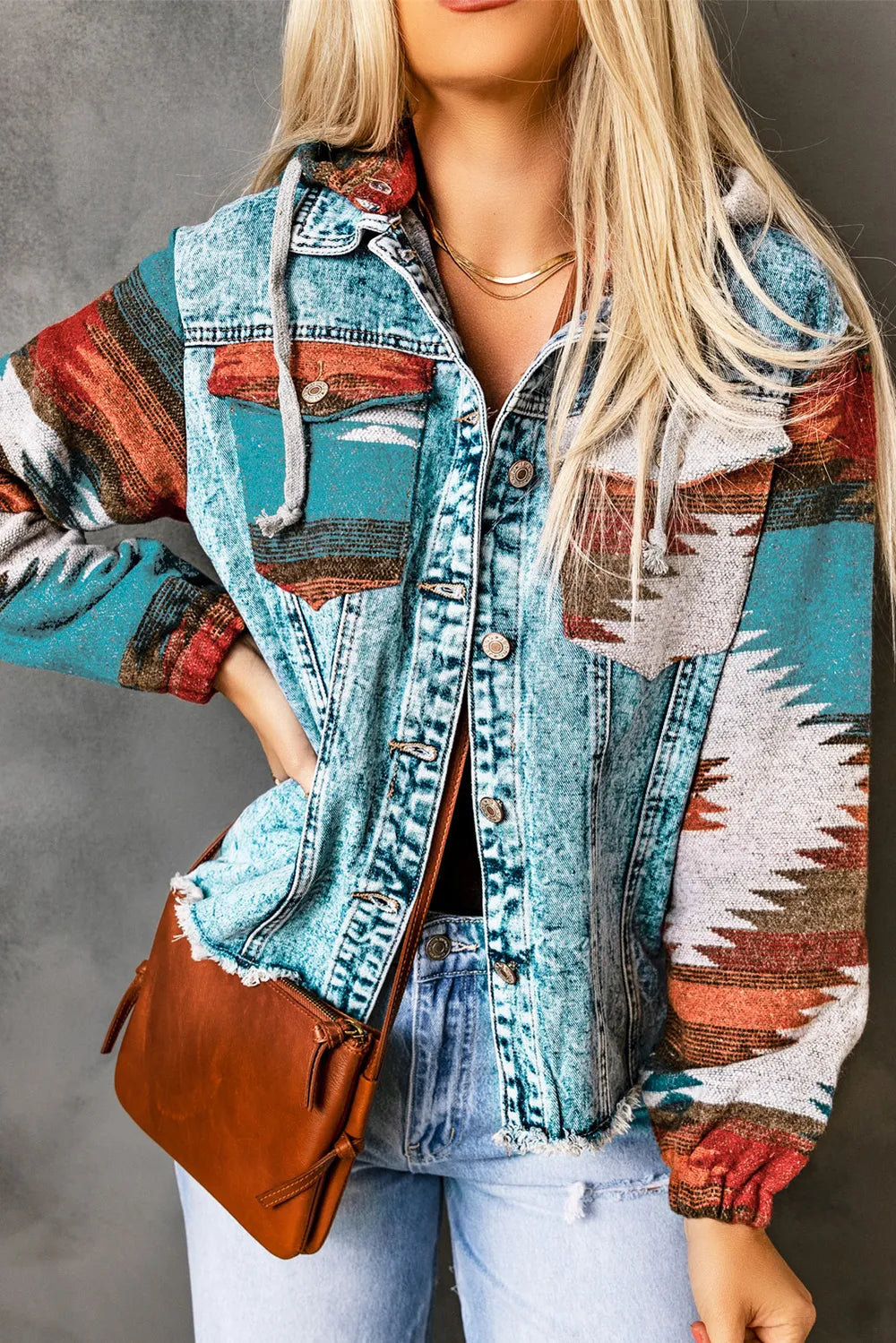 Drawstring hooded pocketed denim jacket with vibrant patterns and front buttons.