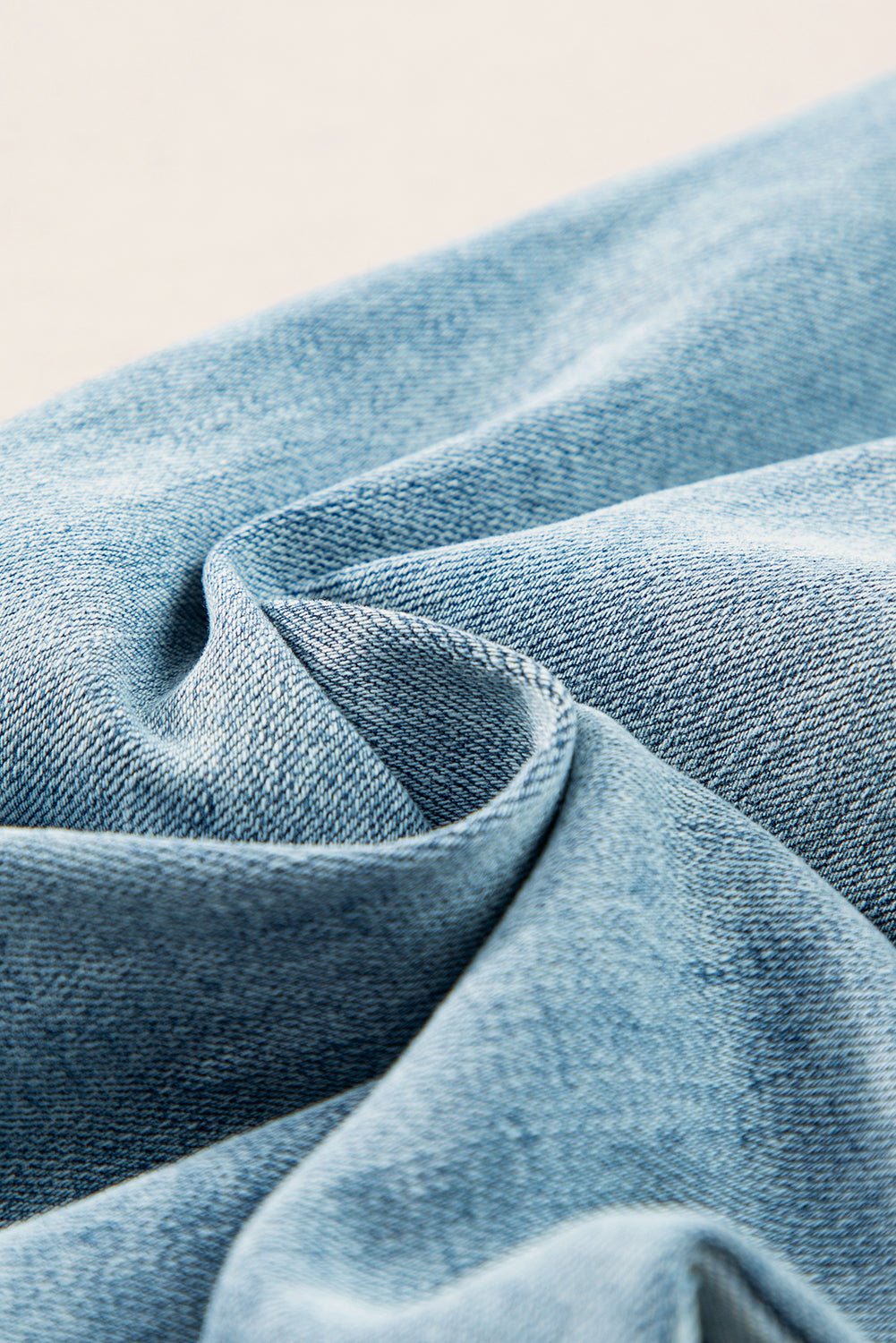 Close-up of light blue denim fabric from wide leg jeans with a slightly stretchy texture.
