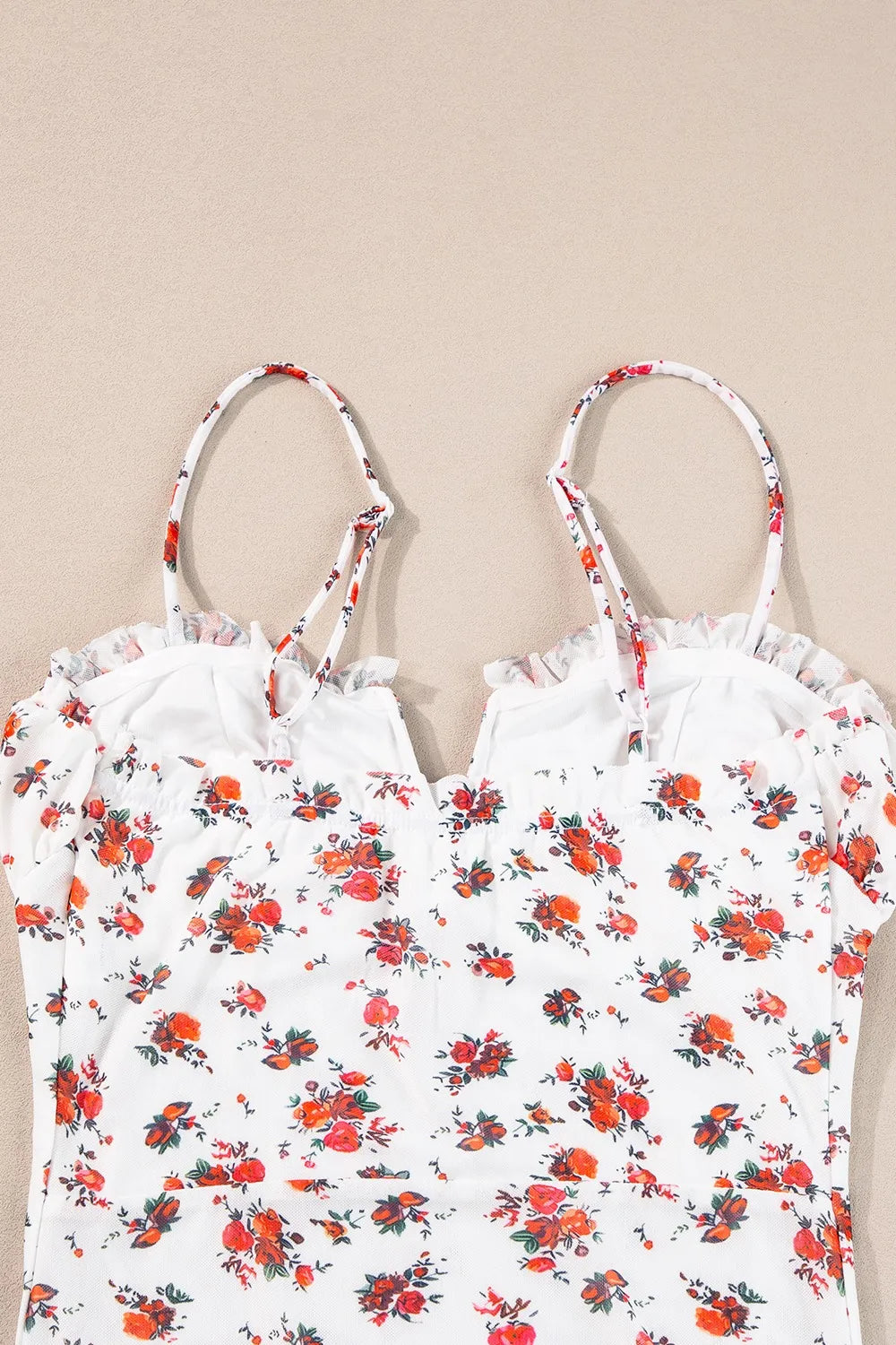 Floral frilled trim spaghetti straps bodysuit with red and green floral pattern on white background.
