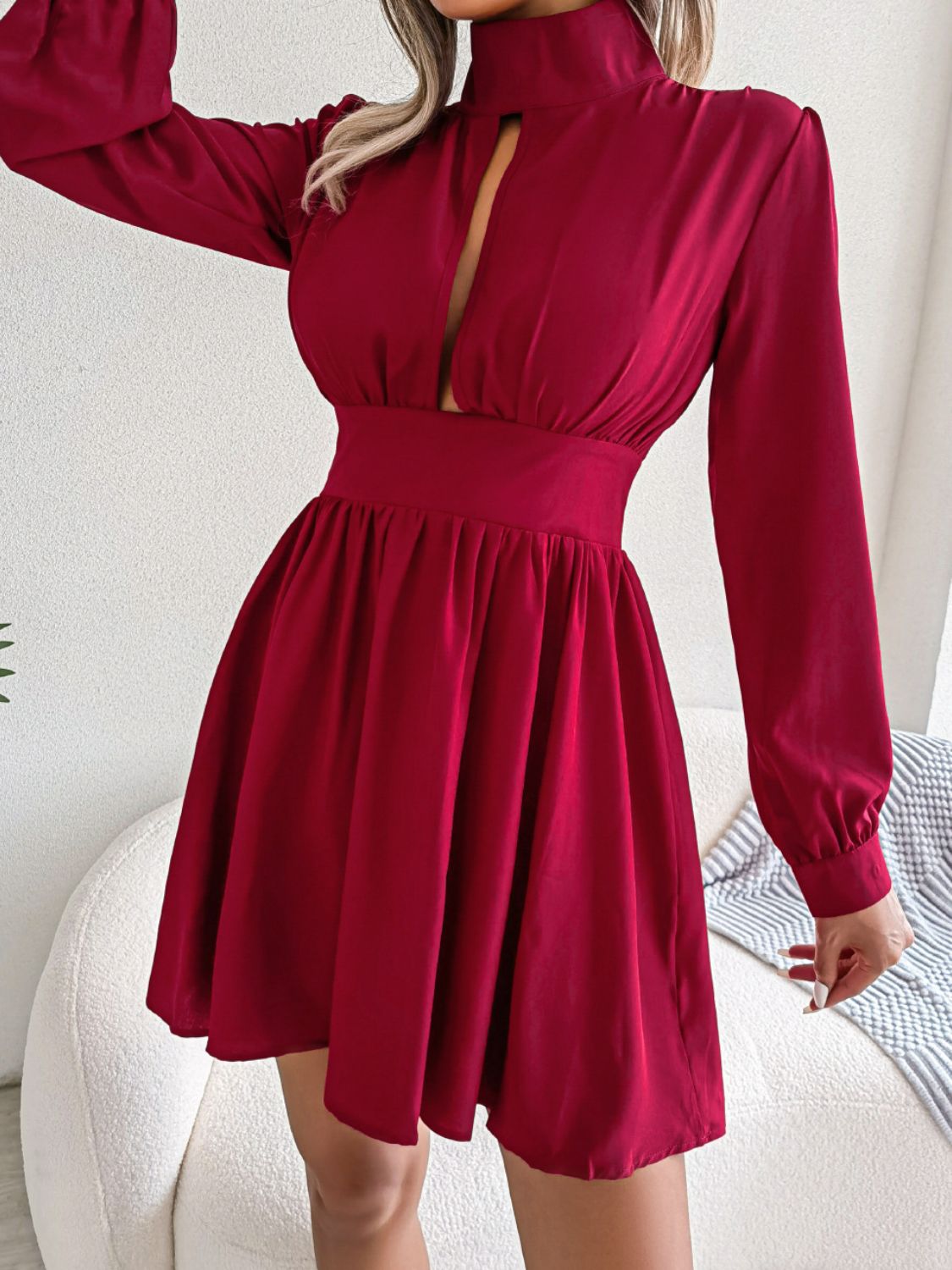 Cutout turtleneck A-line mini dress with keyhole neckline and long sleeves.
