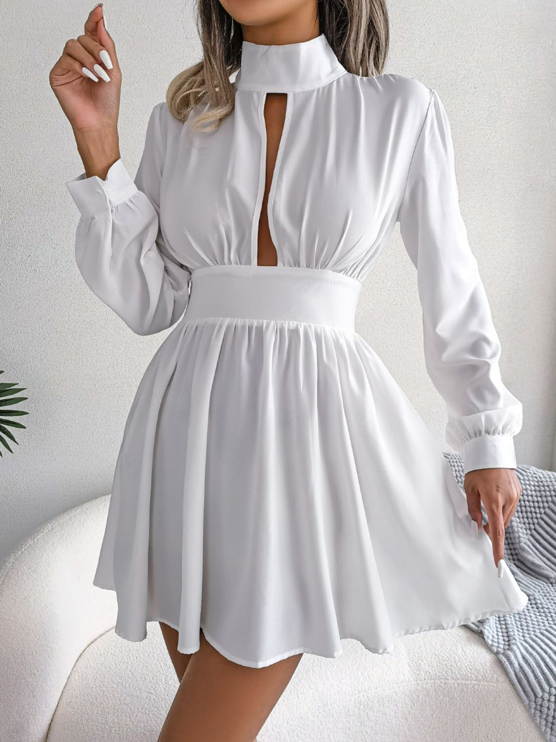 Cutout turtleneck A-line mini dress with long sleeves and keyhole neckline.