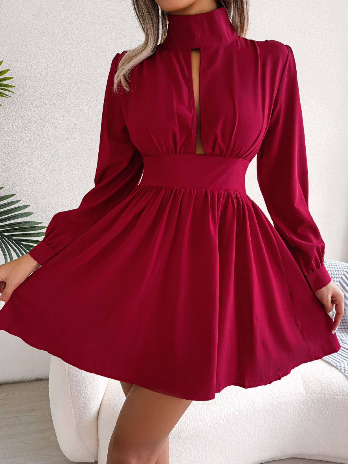 Cutout turtleneck A-line mini dress with long sleeves, solid color, and keyhole neckline.