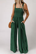 Smocked square neck wide leg jumpsuit with pockets in solid green, sleeveless design.