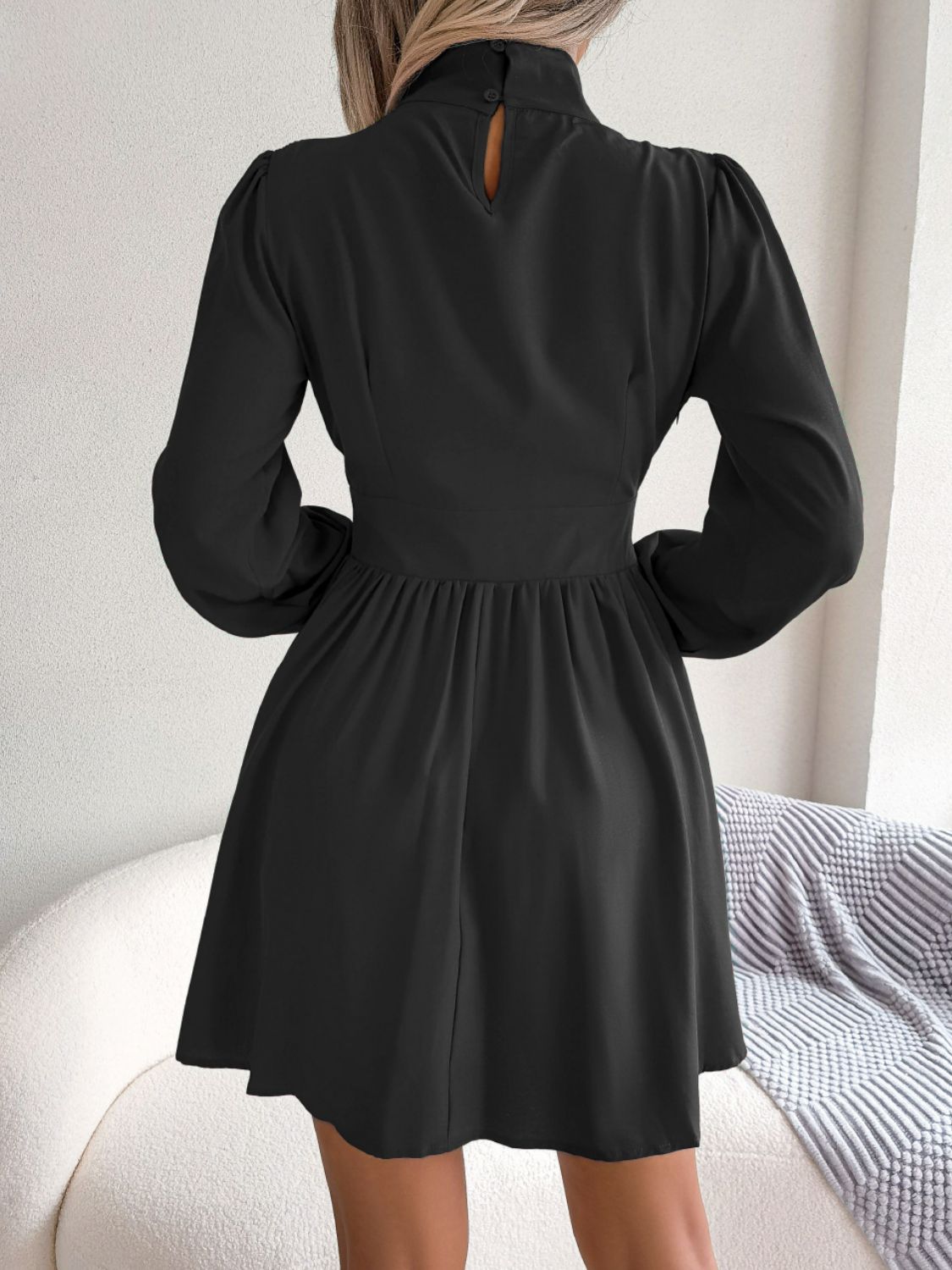 Cutout turtleneck A-line mini dress with buttoned ruched design in solid color, featuring keyhole neckline and long sleeves.