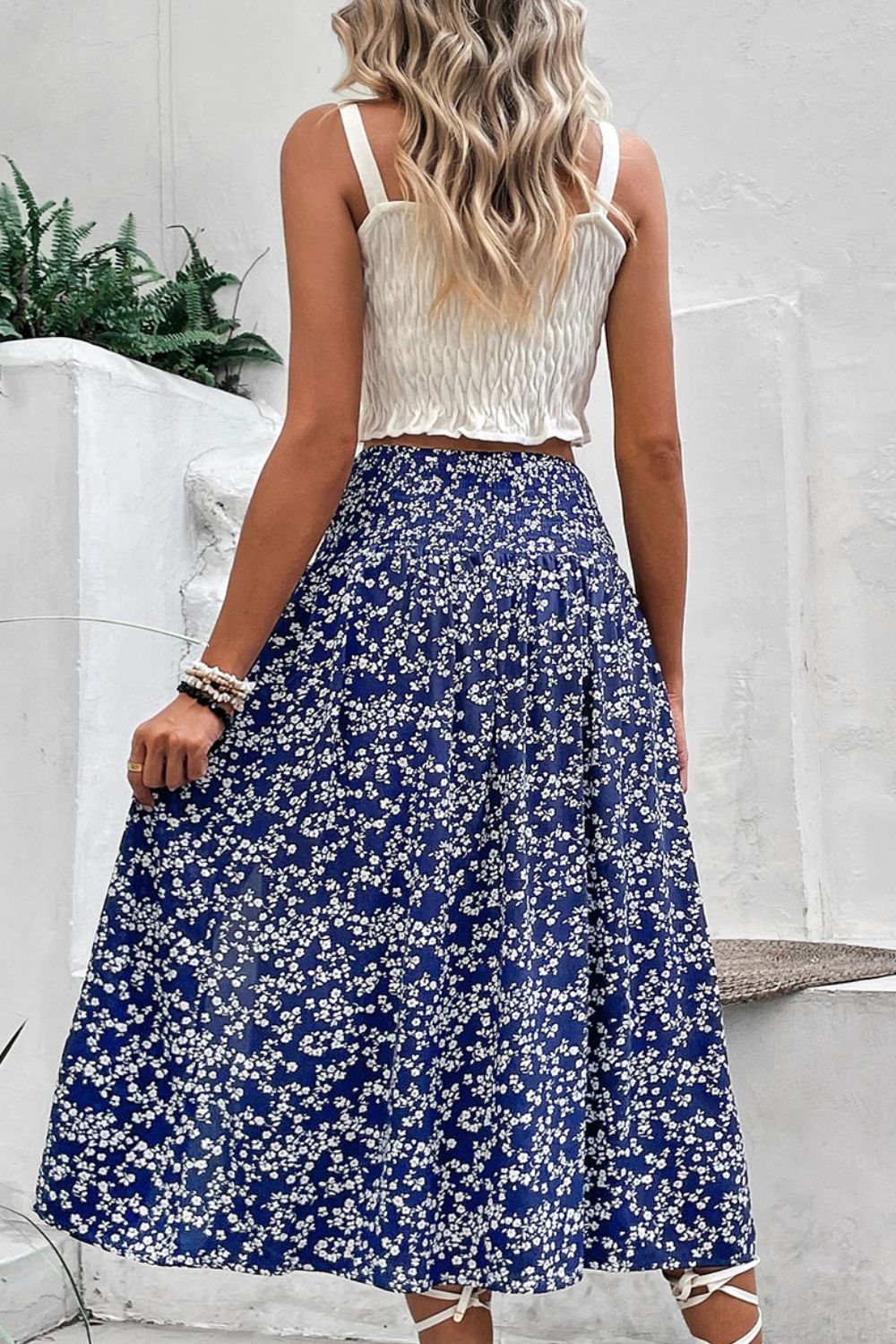 Blue ditsy floral midi skirt with high waist and slit detail, worn with white smocked crop top.