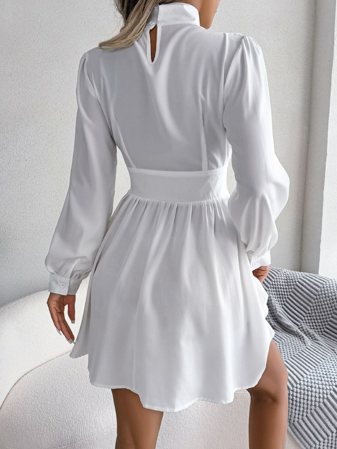 Cutout Turtleneck A-Line Mini Dress with long sleeves and buttoned details in solid white.